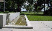 waterelement_beton_maatwerk_waterval_minimalistisch_gazon_open_ruimtelijk_moderne tuin_strak terras_grote tegels_schellevis beton_zitje_vijver